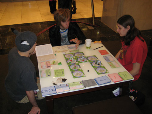 A group plays Collateral Damage: The Anime Board Game in the hotel lobby Saturday night